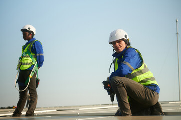 An engineer installs solar panels on the roof.