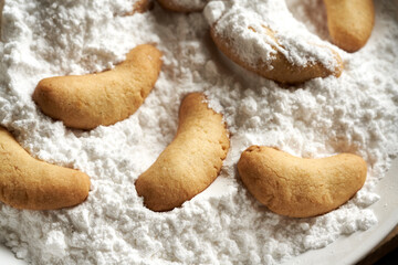 Praparation of traditional Christmas cookies called Kipferl - coating the baked crescents in suger with vanilla