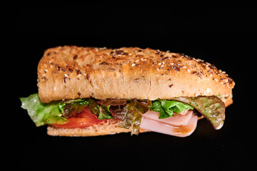 sandwich with seed bread, lettuce, tomato and ham
