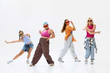 Diverse group of four dancers in vibrant streetwear and sunglasses pose energetically, expressing...