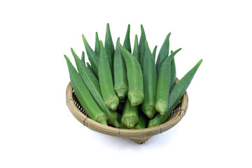 Fresh fruits of okra or Abelmoschus esculentus in wooden basket isolated on  white background  closed up. Raw okra is rich source of dietary fiber and vitamin C and K.