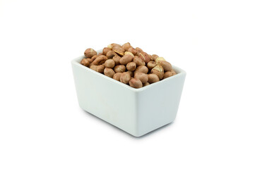 Roasted peanut with peel in white ceramic closed up.