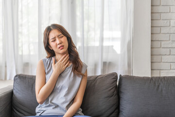 Sick asian women touching neck unwell coughing with sore throat pain,lung...