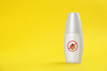 Insect repellent in spray bottle on yellow background, space for text