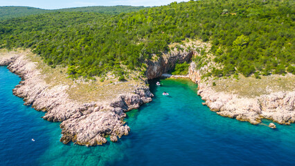 An aerial view of Uvala V. Vran, a secluded cove near Sv. Marek Sand Beach on Krk Island, Croatia, captured by a drone. This beautiful location offers crystal-clear turquoise waters, rugged coastline