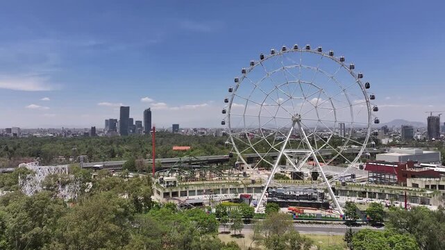 Jib up drone overlooking the Wheel of Fortune in Aztlan Park, revealing Bosque de Chapultepec, Mexico City