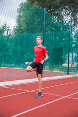 Fototapeta premium An athlete performs special running exercises at the stadium.