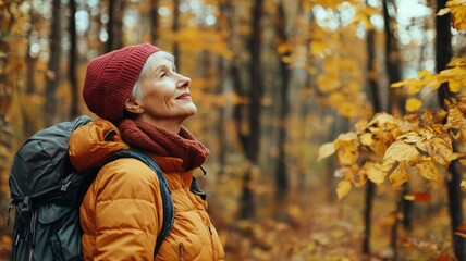 Elderly woman hiking in autumn forest, enjoying nature