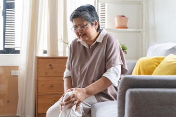 Arthritis is a chronic disease problem in elderly healthcare, Asian old female touching her leg...