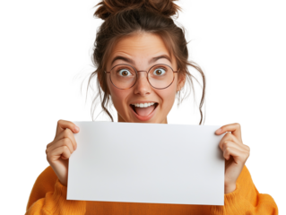 A cheerful young woman with glasses expresses joy while holding a blank white sign in her hands. She has a playful hairstyle and is wearing a cozy mustard-colored sweater, showcasing her excitement an