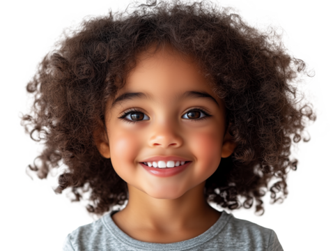 A young child with curly hair displays a radiant smile, showcasing bright eyes and joyful expression. The soft lighting highlights their cheerful demeanor, creating a warm atmosphere focusing on sheer