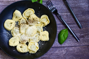 Home made vegetarian  italian   Tortellini with pesto genovese filled with   spinach   and parmesan cheese, decorated with fresh basil