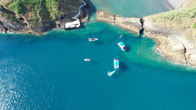 Aerial view of Ilheu de Vila Franco do Campo on a bright summer day, showcasing its turquoise lagoon and volcanic beauty off Sao Miguel, Azores, Portugal