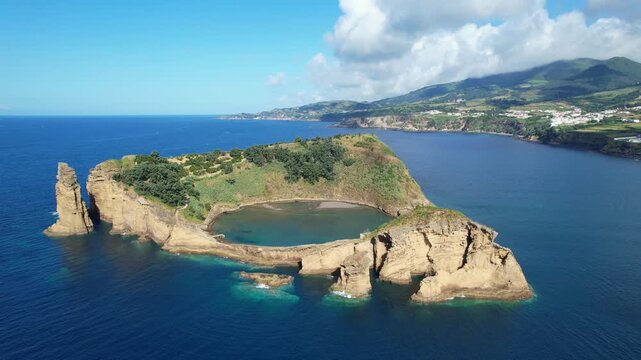 Aerial view of Ilheu de Vila Franco do Campo on a bright summer day, showcasing its turquoise lagoon and volcanic beauty off Sao Miguel, Azores, Portugal