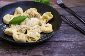 Home made vegetarian  italian   Tortellini with pesto genovese filled with   spinach   and parmesan cheese, decorated with fresh basil