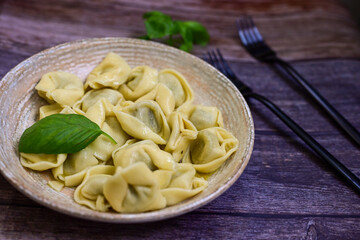 Home made vegetarian  italian   Tortellini with pesto genovese filled with   spinach   and parmesan cheese, decorated with fresh basil