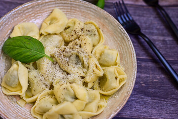 Home made vegetarian  italian   Tortellini with pesto genovese filled with   spinach   and parmesan cheese, decorated with fresh basil