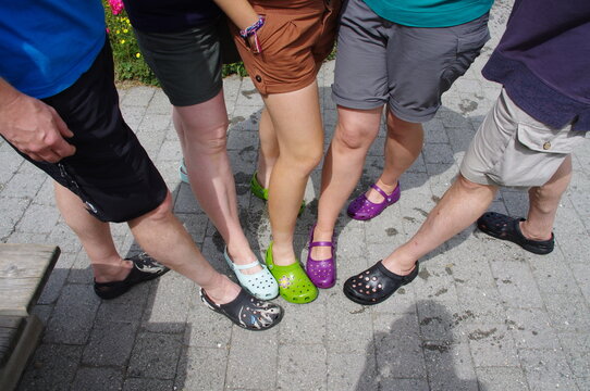 Friends wearing Crocs shoes of different colours  and designs. 