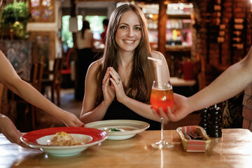 The waiters brought the food. Woman is in the restaurant
