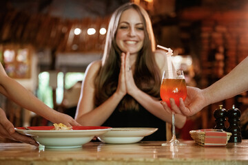 The waiters brought the food. Woman is in the restaurant