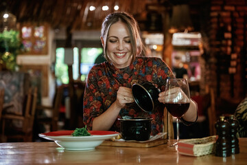 Woman is in the restaurant with food and drink