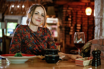 Woman is in the restaurant with food and drink