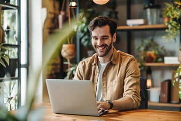 Smiling man working on laptop in a modern office.