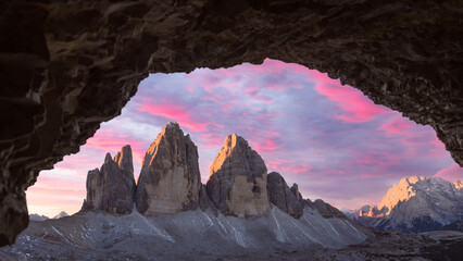 Panoramic view from the cave on Tre Cime Di Lavaredo peaks in incredible purple sunrise light....