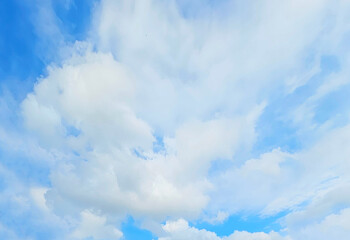 A clear, bright blue sky filled with fluffy white clouds, creating a serene and calming atmosphere