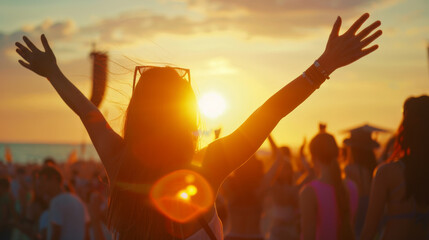 A crowd of people enjoying a beach party at sunset, with one person silhouetted against the vibrant sky, arms raised in celebration of freedom and joy.