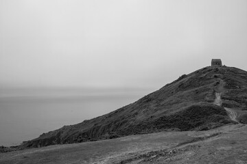 Fototapeta premium Rame Head Chapel located on a high cliff in the Mount Edgcumbe Country Park Cornwall England on a misty summer day in black and white