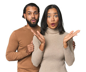 Fototapeta premium Young Latino couple in studio surprised and shocked.