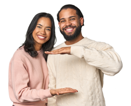 Young Latino couple in studio holding something with both hands, product presentation.