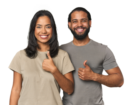 Young Latino couple in studio smiling and raising thumb up