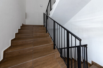 Modern stair case between floors. Stairs with metallic rail  in modern building