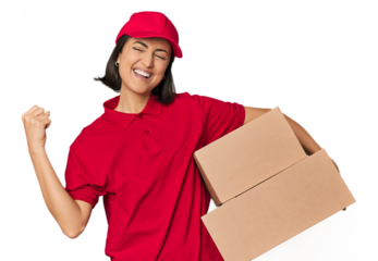 Young Caucasian delivery woman with boxes raising fist after a victory, winner concept.