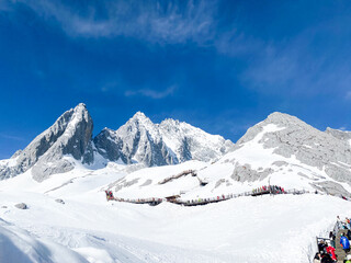 Panoramal nature view Jade Dragon Snow Mountain with soft white cloud on blue sky and soft sunlight in morning, Shangri-La City or Xiang Ge Le La at Yunnan, China