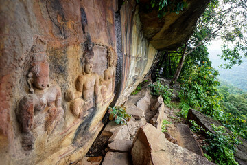 The ancient low relief stone carving on the cliff is a Buddha image at Pha Mo e- Daeng, Khao Phra...