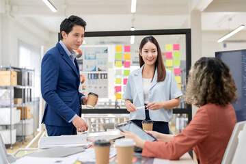 Asian business team brainstorming ideas in modern office. Creative professionals sharing innovative strategies during a collaborative meeting. Contemporary workspace with teamwork diverse perspective