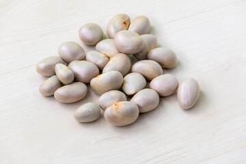 Dry jackfruit seeds on wooden surface.
