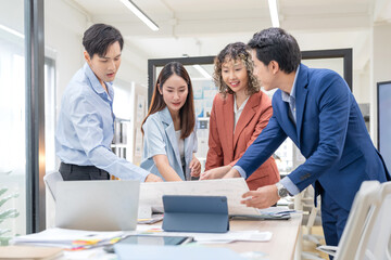 Creative Asian professionals brainstorming in a modern office. Business team collaborating on...