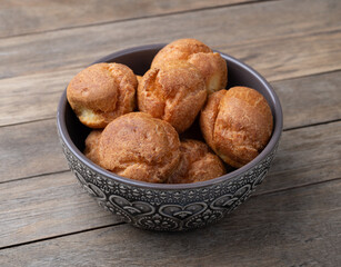 Broa, typical brazilian corn flour bread in a bowl over wooden table
