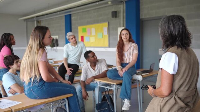 Teenager High School students talking to senior tutor teacher - Group support conversation in Higher Education