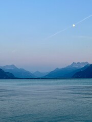 Lake Geneva and Swiss Alps landscape view at dusk with the moon in the sky.  No people. 