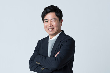 腕組みをする50代男性