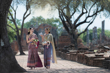 Fototapeta premium Asia woman in Thai dress traditional women in traditional Dress on Buddhist on background. Portrait women in traditional clothing , Thai traditional in Ayutthaya Thailand.thai model portrait