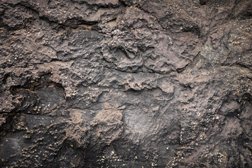 Empty black brown stone wall on rock for abstract  background and texture. beautiful patterns, space for work, banner,seamless wallpaper, close up.