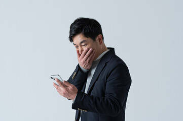 スマートフォンを見て驚く50代男性