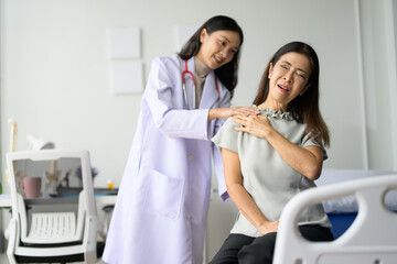 Obraz premium Female Doctor Examining Senior Woman's Shoulder in Medical Office for Pain Relief and Physical Therapy