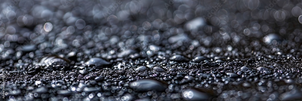 Poster water droplets rest on a smooth dark surface, reflecting light softly, creating a serene and tranqui